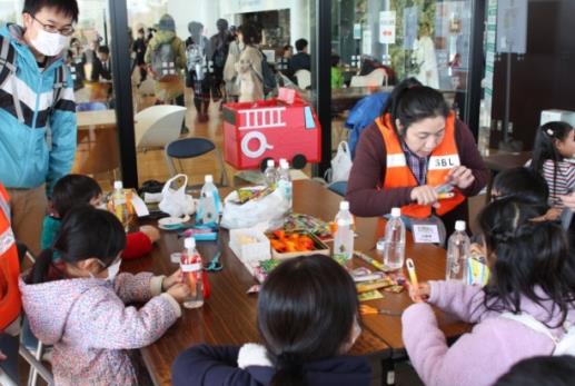仙台市地域防災リーダーが子供達に作り方を教えている写真