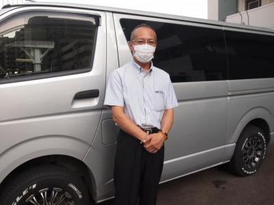 火葬炉を積んだ専用車両と代表の山﨑敏彦さんの写真