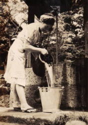 女性が井戸で水を汲んでいる写真