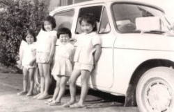 子どもたちが自動車の前に並んでいる写真