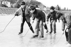 凍った広瀬川でスケートを楽しむ子どもの写真